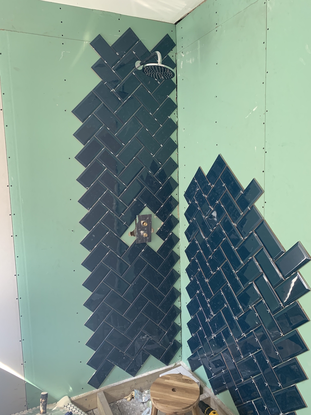 Starting the herrinbone tile pattern with shower head installed